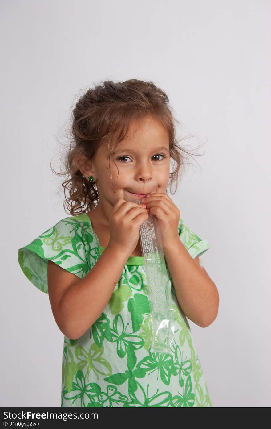 A three year old girl enjoring a popsicle on a summer day.