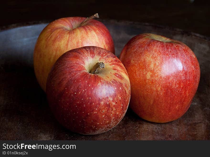 Three fresh red apples on dark wooden background. Three fresh red apples on dark wooden background