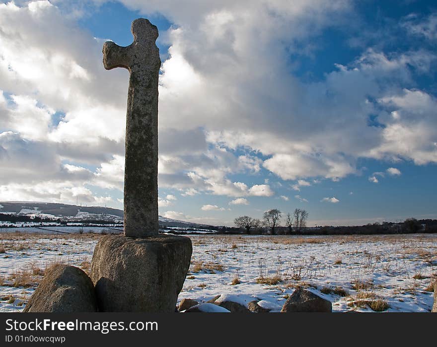 Stone cross in snow