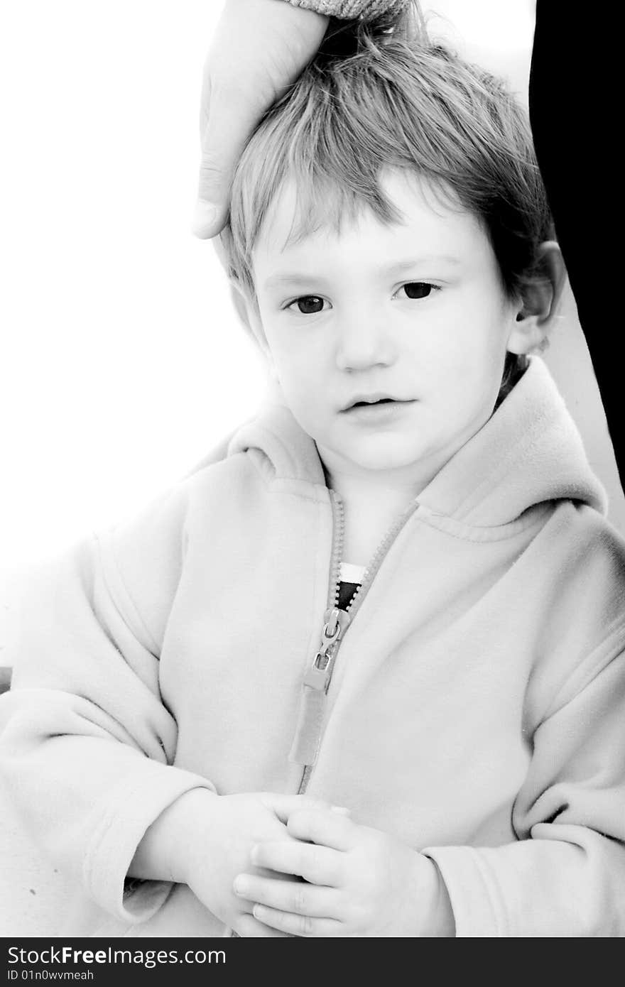 Boy's portrait with father's hand on his head over white