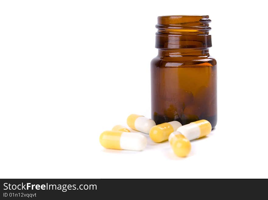 Glass bottle with yelllow capsules on white background