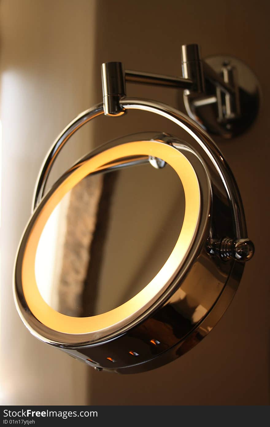 Round mirror with light hanging on the wall