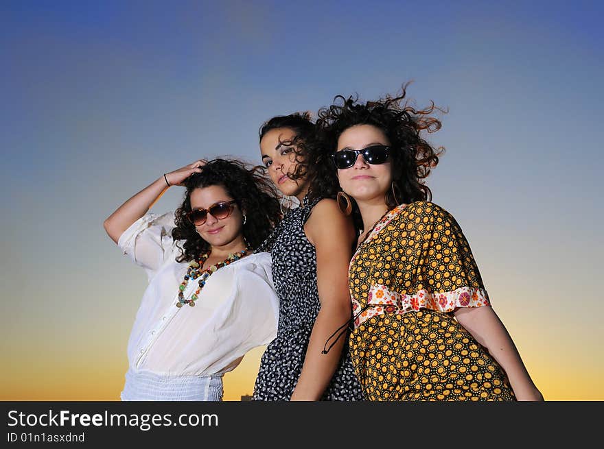 Portrait of three trendy girls posing at sunset. Portrait of three trendy girls posing at sunset