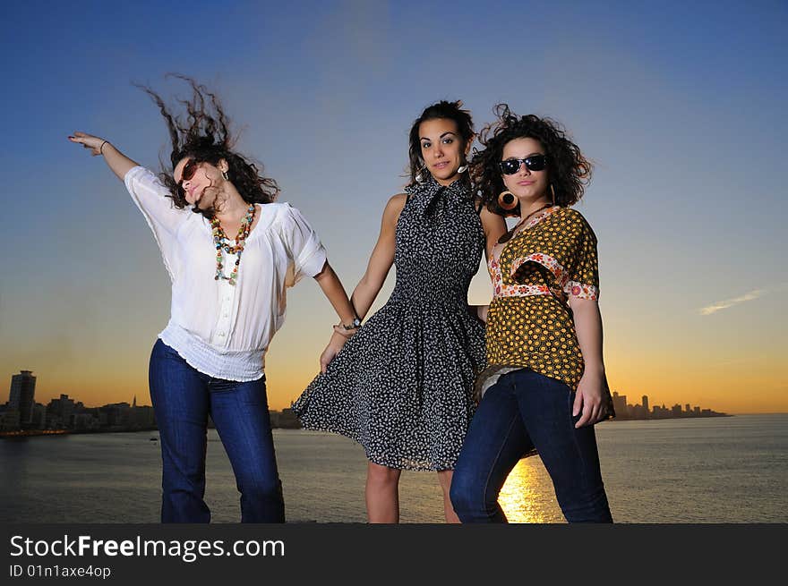 Portrait of three trendy girls posing at sunset. Portrait of three trendy girls posing at sunset