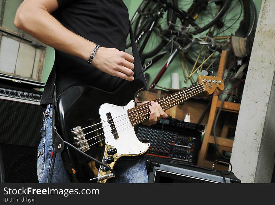 Portrait of man playing electric bass guitar on grunge garage. Portrait of man playing electric bass guitar on grunge garage