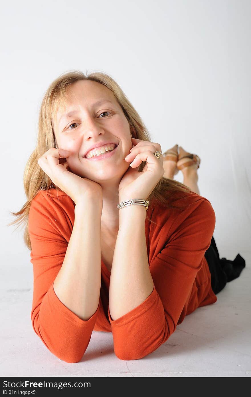 A colorful women laying down with hands under her chin. A colorful women laying down with hands under her chin