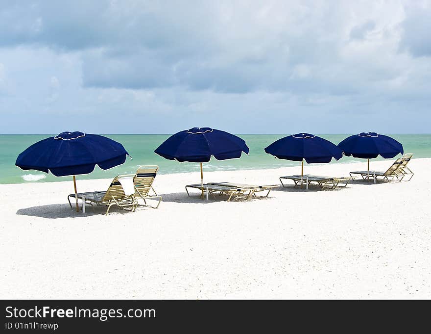 Lounge chairs and parasols on a pristine white sand