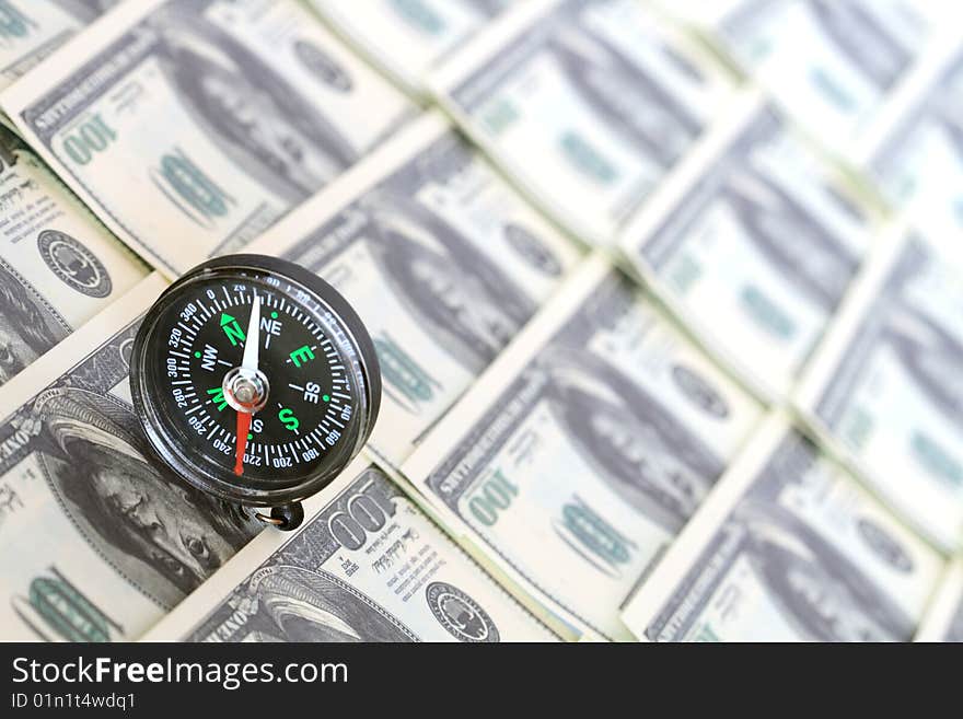 Compass standing on background with one hundred dollar banknotes. Compass standing on background with one hundred dollar banknotes