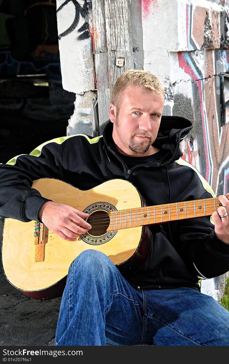 A man holding his guitar ready to play