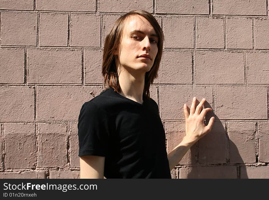 Sexy man standing in front of a brick wall