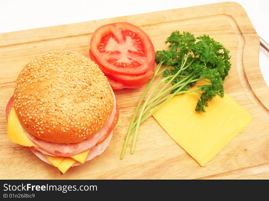 Sandwich and ingredients on wooden plate. Sandwich and ingredients on wooden plate.