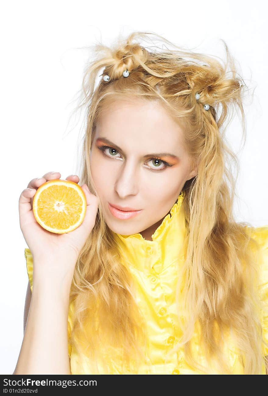 Young girl in yellow dress with piece of orange. Young girl in yellow dress with piece of orange