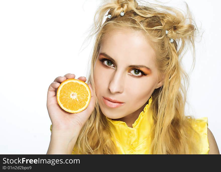 Young girl in yellow dress with piece of orange. Young girl in yellow dress with piece of orange