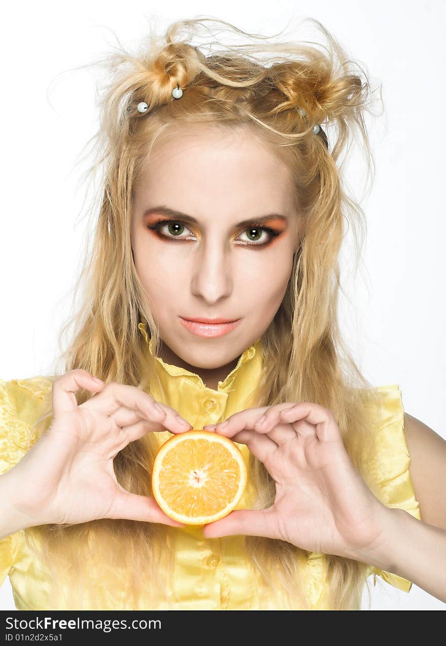 Young girl in yellow dress with piece of orange. Young girl in yellow dress with piece of orange