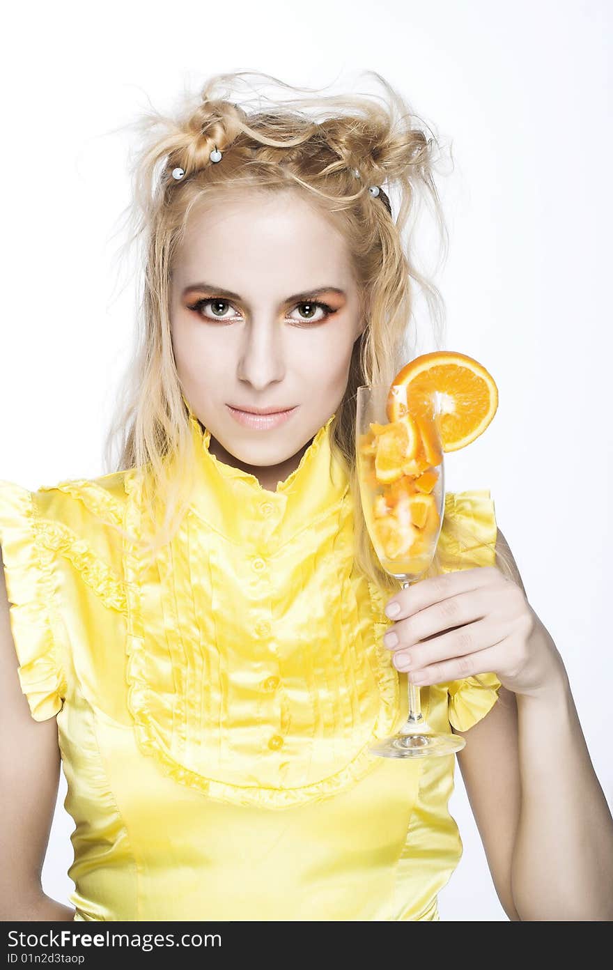 Young girl in yellow dress with piece of orange. Young girl in yellow dress with piece of orange