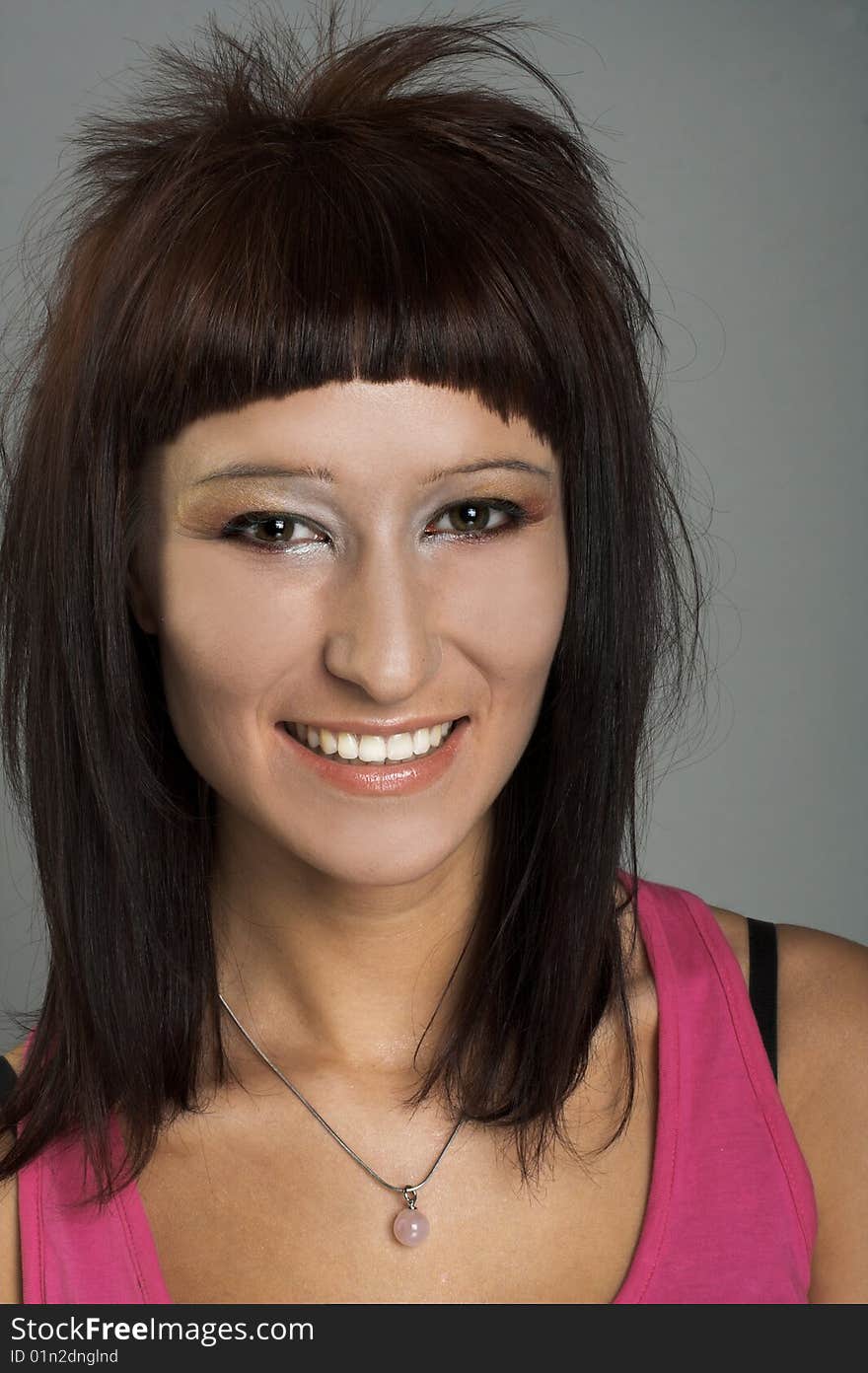 Portrait of young smiling woman in pink shirt