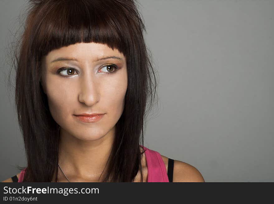 Portrait of young  woman witn dark hair in pink shirt. Portrait of young  woman witn dark hair in pink shirt