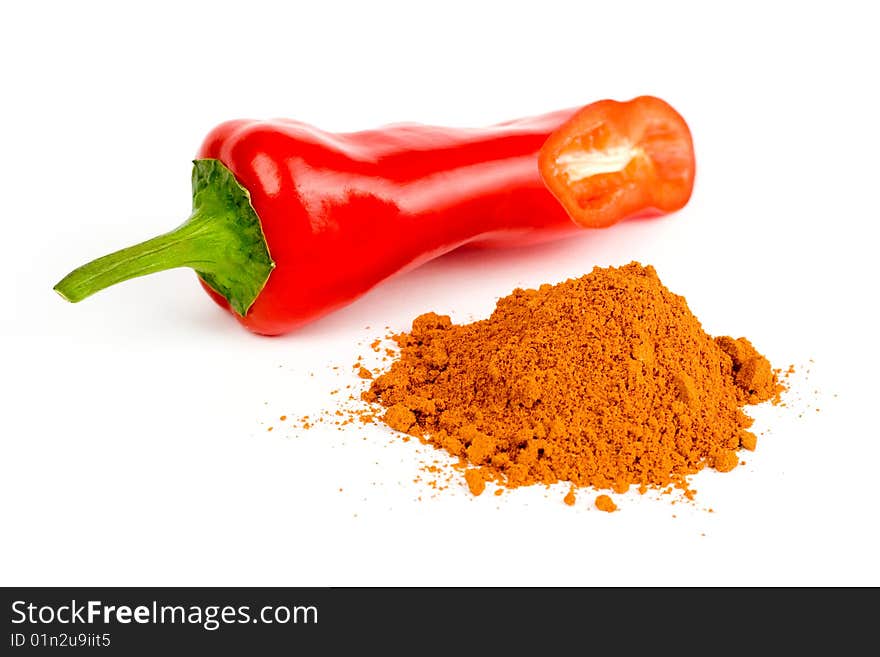 A composition of a cut pod of red pepper and a little of ground red pepper on a white background. A composition of a cut pod of red pepper and a little of ground red pepper on a white background