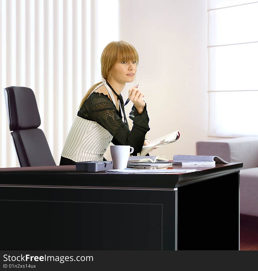 Beautiful young blonde businesswoman in her office