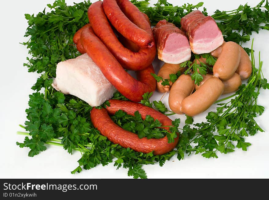 Sausage wares on a background greenery, studio shot