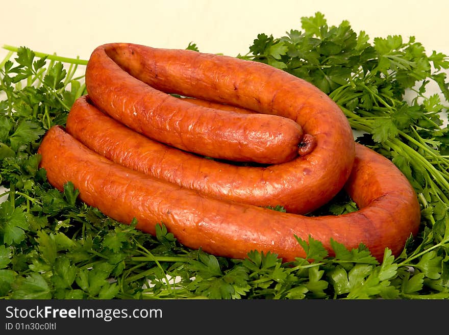 Sausage wares on a background greenery, studio shot