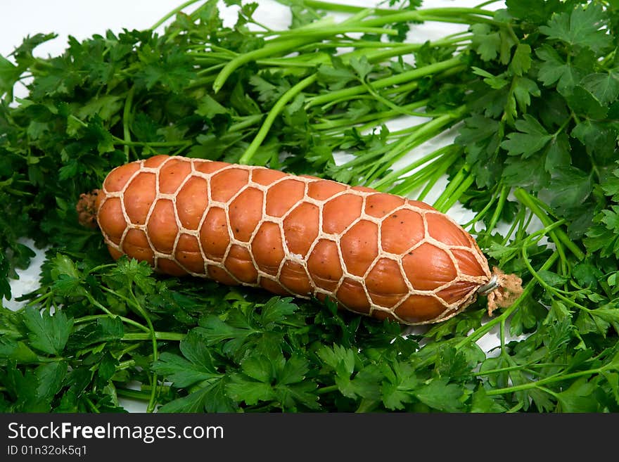 Sausage wares on a background greenery, studio shot