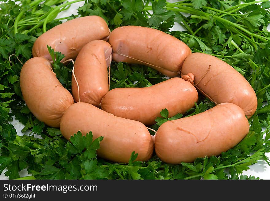 Sausage wares on a background greenery, studio shot