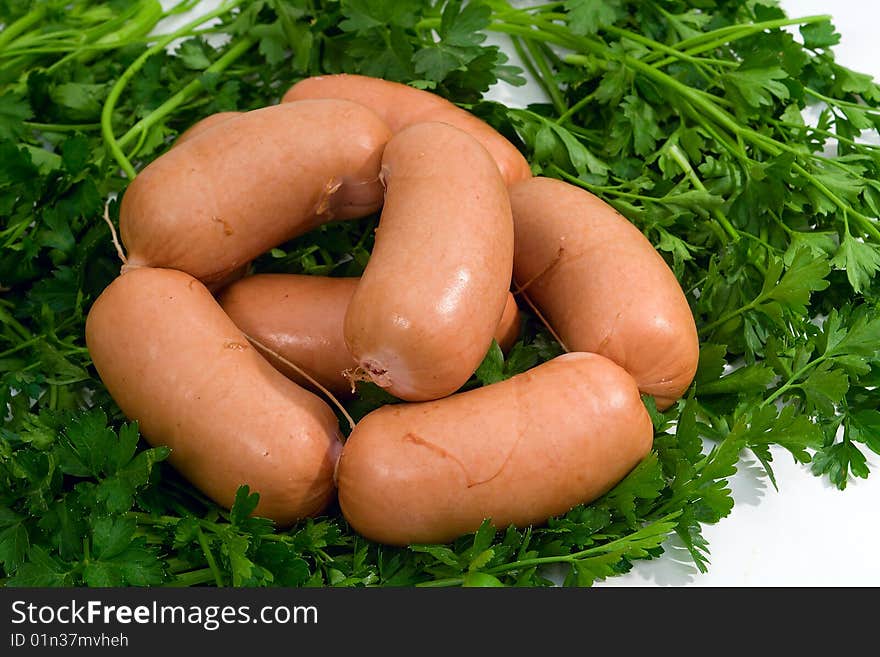 Sausage wares on a background greenery, studio shot