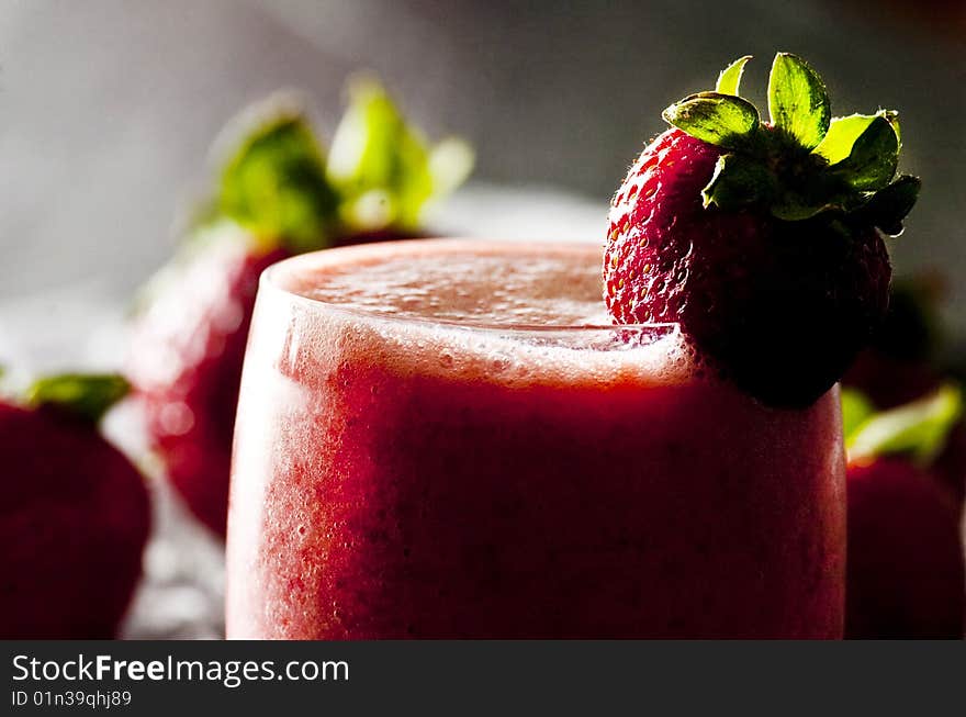 Backlit glass of freshly made strawberry smoothie. Backlit glass of freshly made strawberry smoothie