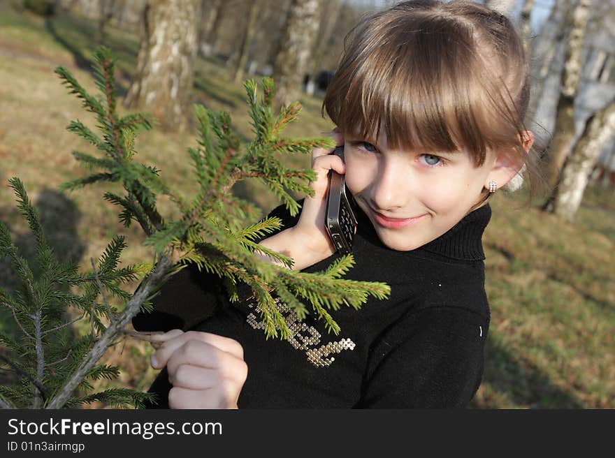 Portrait of a little girl with phone in park. Portrait of a little girl with phone in park