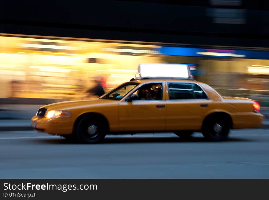 Taxi on an urban street at night, blurred as it races down the street. Use the empty copyspace on top to place your message. Taxi on an urban street at night, blurred as it races down the street. Use the empty copyspace on top to place your message.