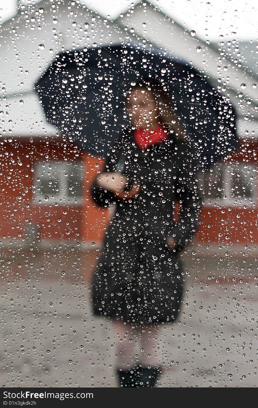 Beautiful girl with red scarf and umbrella for glass with drop of water