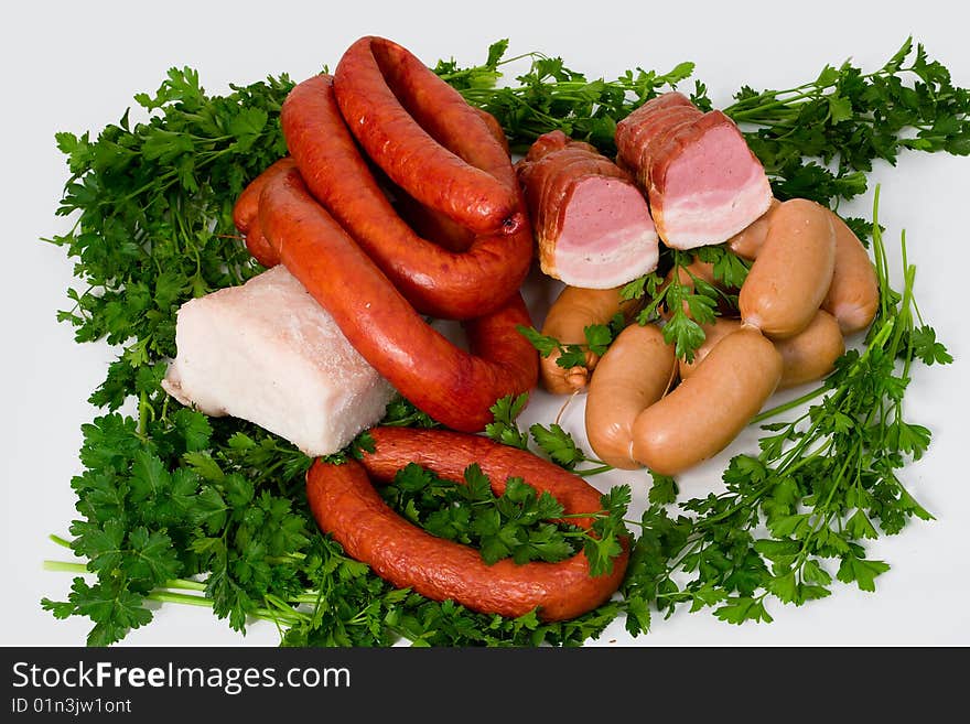 Sausage wares on a background greenery, studio shot