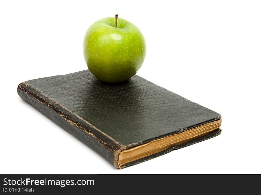 Book and green apple. White background