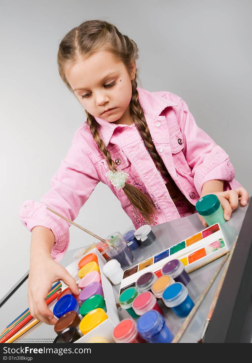 Beautiful little girl drawing with brush