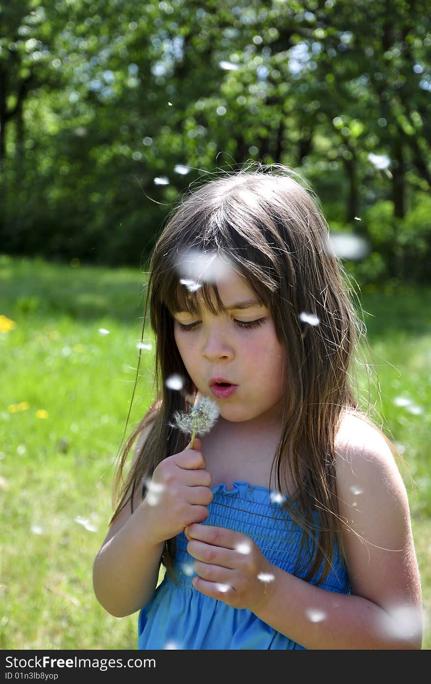 Little girl closeup portrait with dandelion