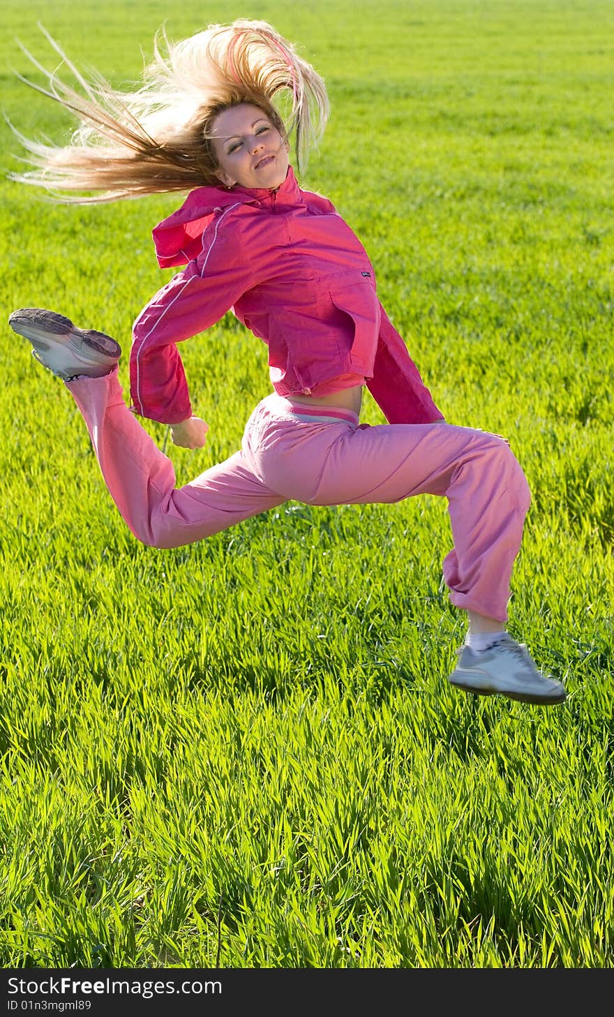 Beautiful young woman jumps above green meadow. Beautiful young woman jumps above green meadow