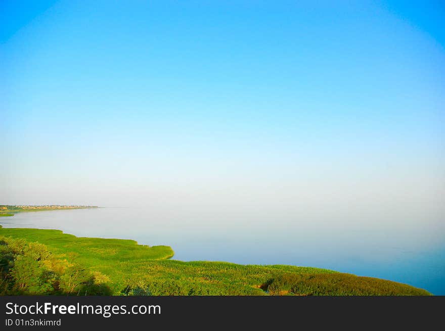 Grassy dunes next to the sea under a nice blue sky