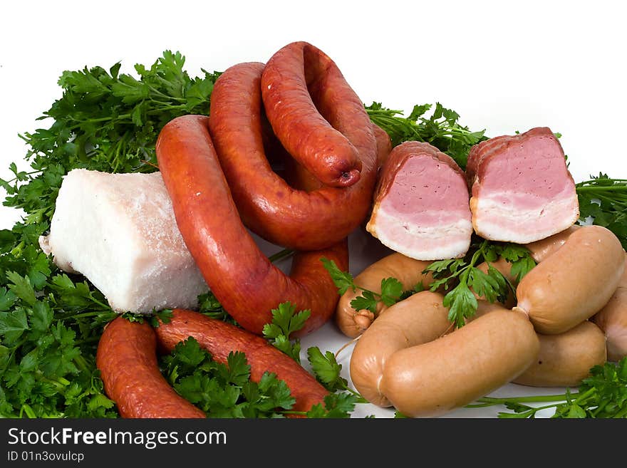 Sausage wares on a background greenery, studio shot