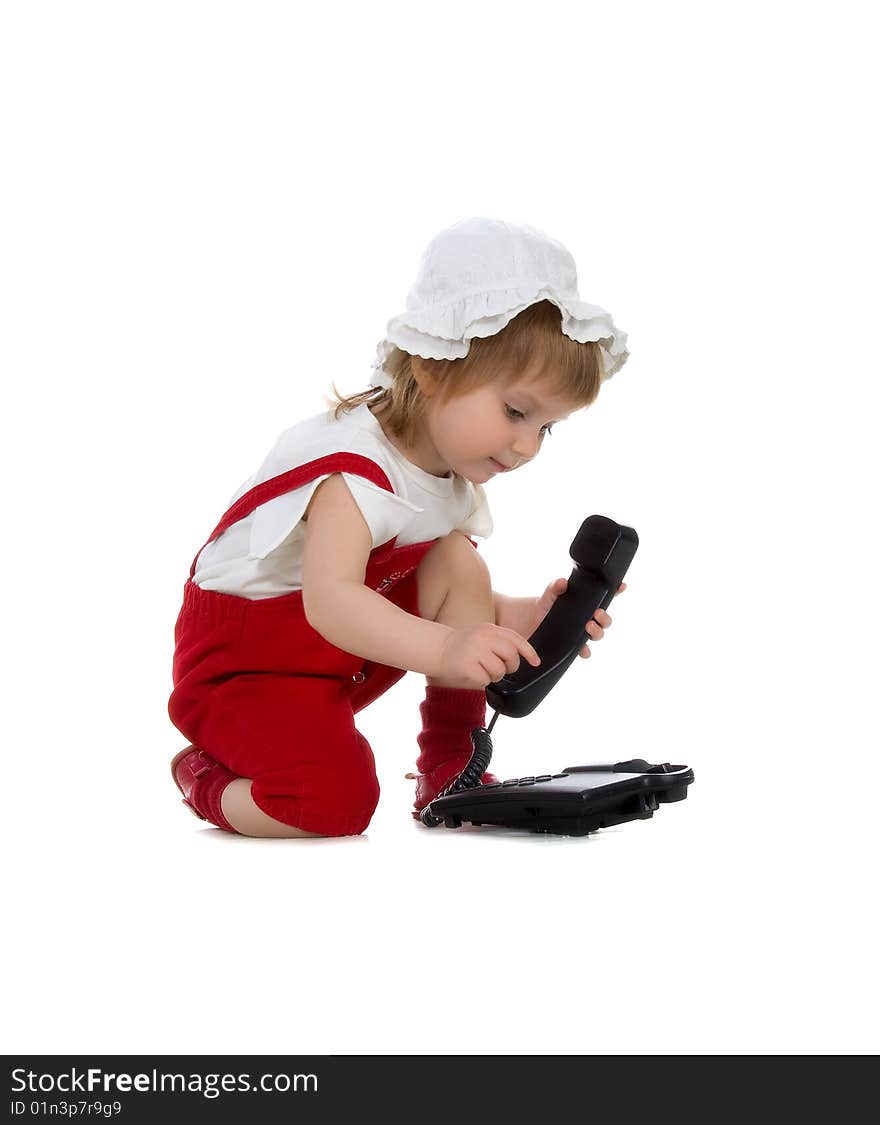 Little girl speaks on the phone. Studio shot