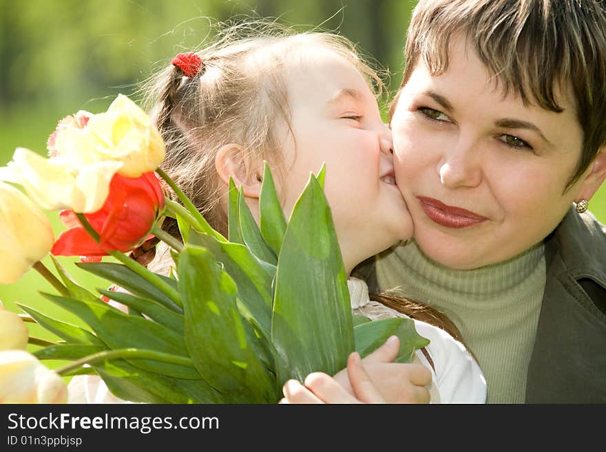 Little girl kissing her mom. Little girl kissing her mom