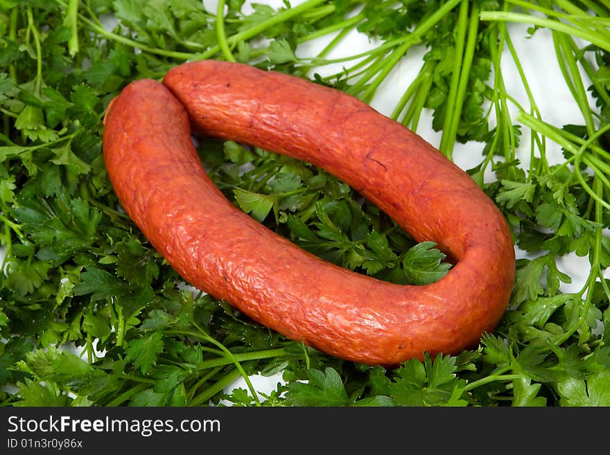 Sausage wares on a background greenery, studio shot