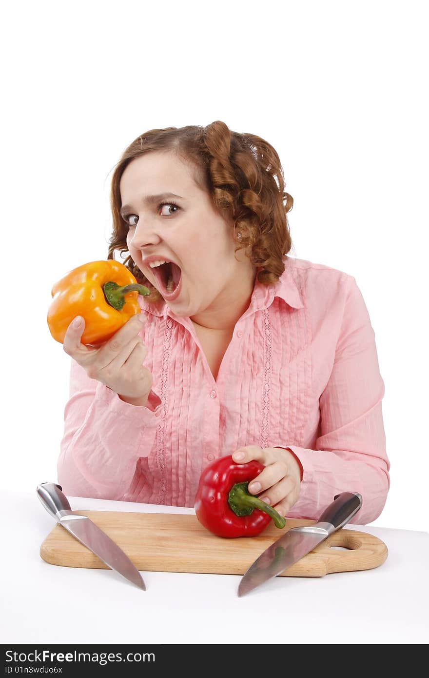 Woman wants to eat sweet peppers. Pretty smiling girl is holding sweet pepper.  Housewife with sweet peppers and knifes. Isolated over white background. Woman wants to eat sweet peppers. Pretty smiling girl is holding sweet pepper.  Housewife with sweet peppers and knifes. Isolated over white background.