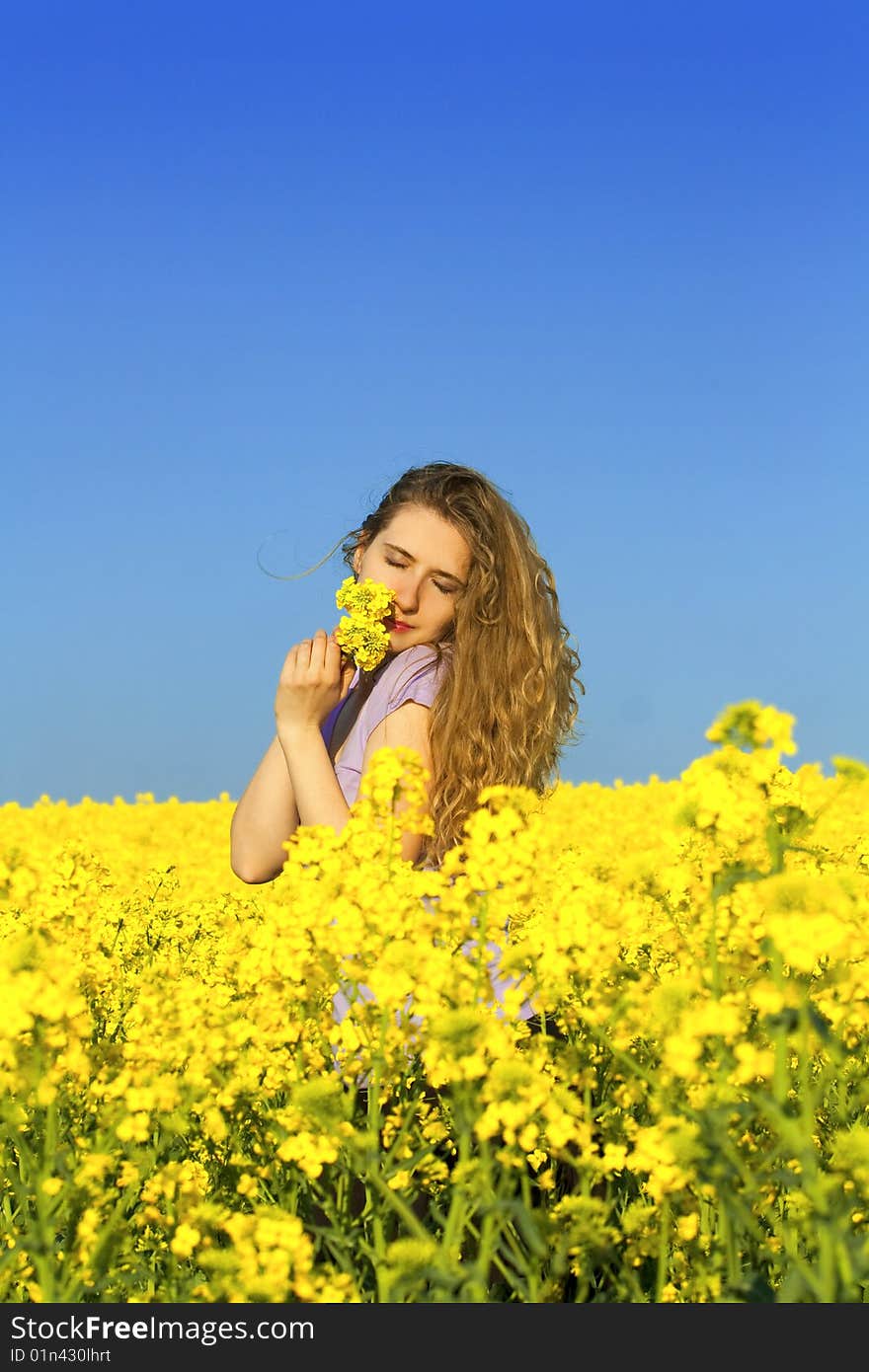 Woman in rape(canola) field smelling flowers. Woman in rape(canola) field smelling flowers