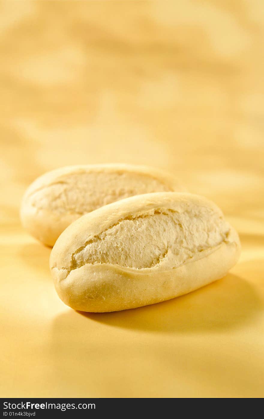 Two little fresh baguette laying on a table. Two little fresh baguette laying on a table