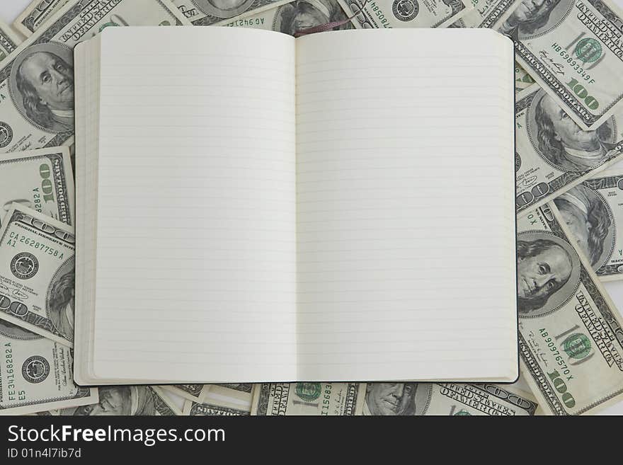 Blank Notebook with one hundred dollar bills in background. Blank Notebook with one hundred dollar bills in background