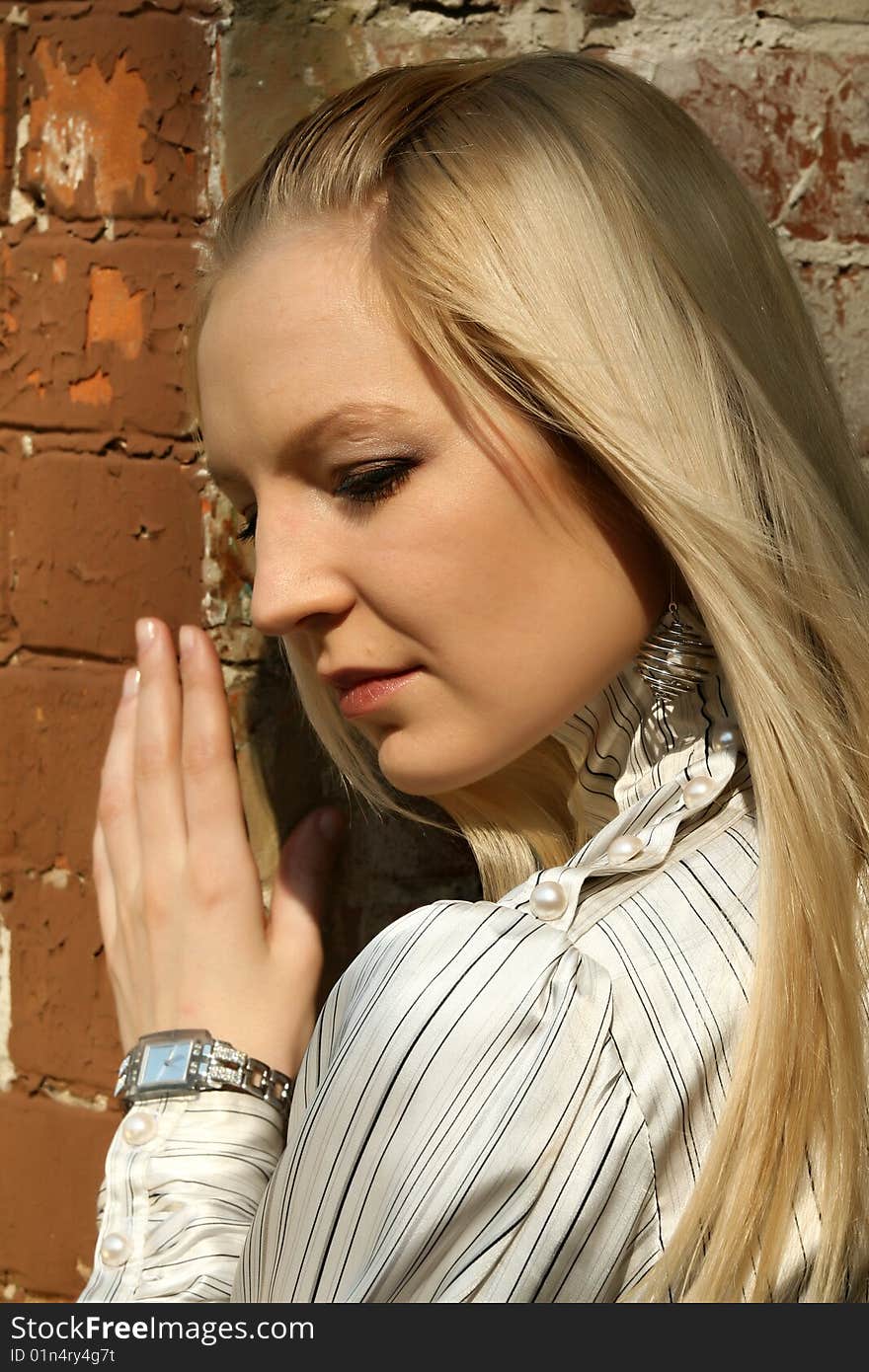 Portrait of sad woman standing at the brick wall