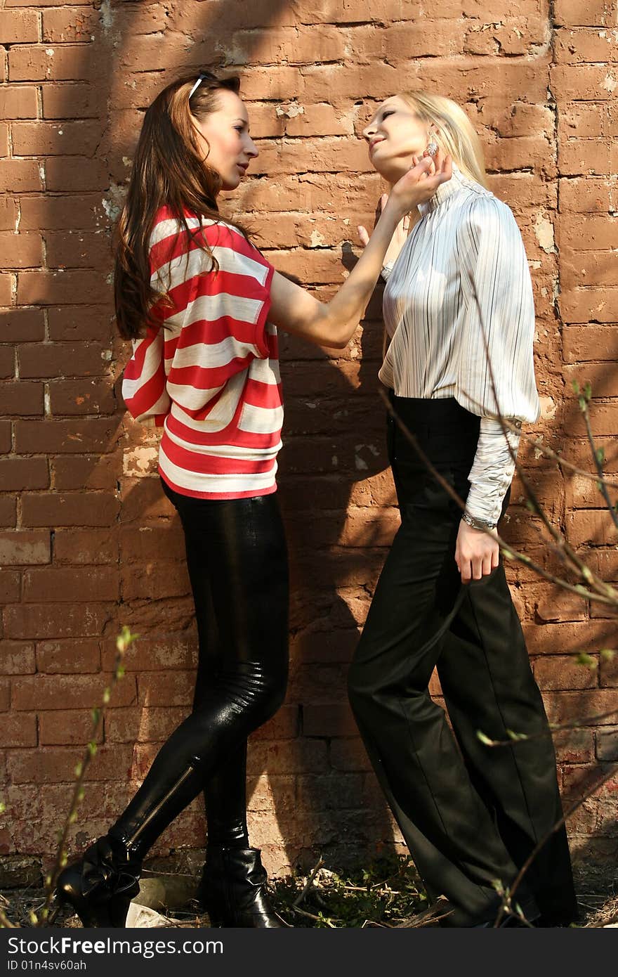 Two women talking about fashion at the wall. Two women talking about fashion at the wall