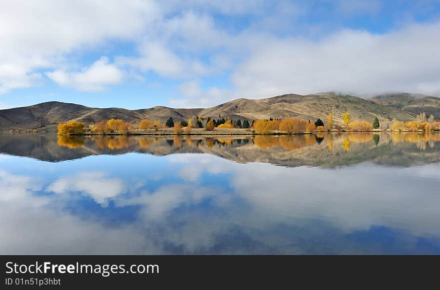 Wide angle landscape, yellow trees beside the lake, perfect reflection. Wide angle landscape, yellow trees beside the lake, perfect reflection