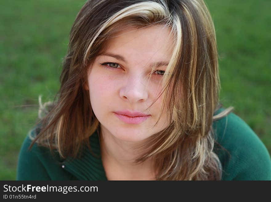 Portrait of beautiful girl on a background of green grass